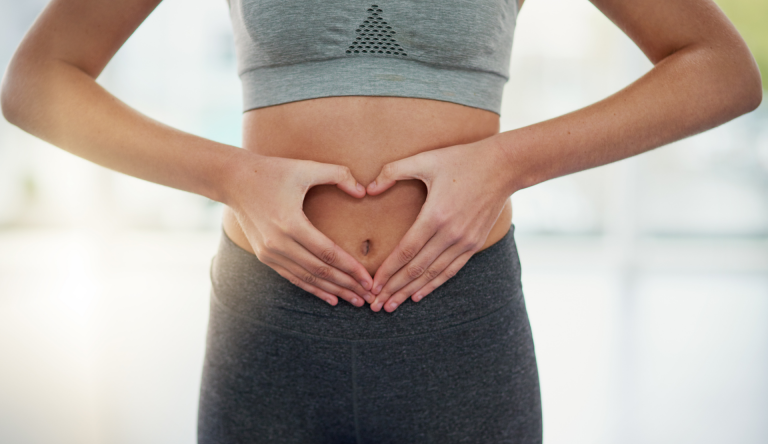Frau legt ihre Hände in Herzform auf den Bauch. Symbol für eine gesunde Verdauung und erfolgreiche Darmsanierung in der Naturheilpraxis Karin Kossek in Duisburg.